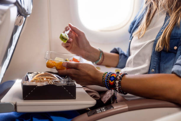 Woman enjoying a gourmet meal at her flight airplane meal
